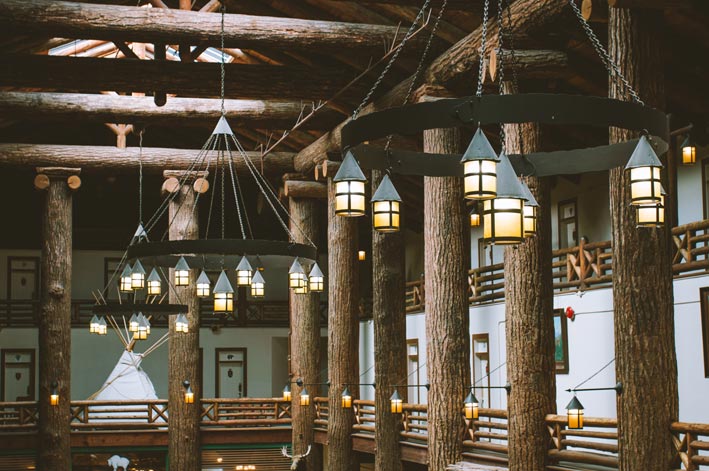 Rustic chandeliers hang from the ceiling of the wooden Glacier Park Lodge