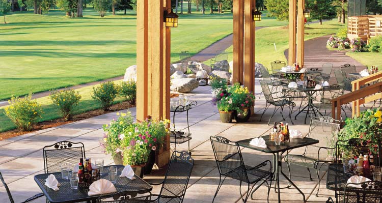 A patio adjacent to a lush golf course.