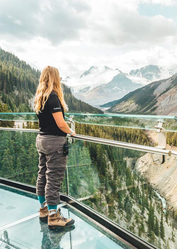 A person stands on the Glacier Skywalk looking over into a wide valley