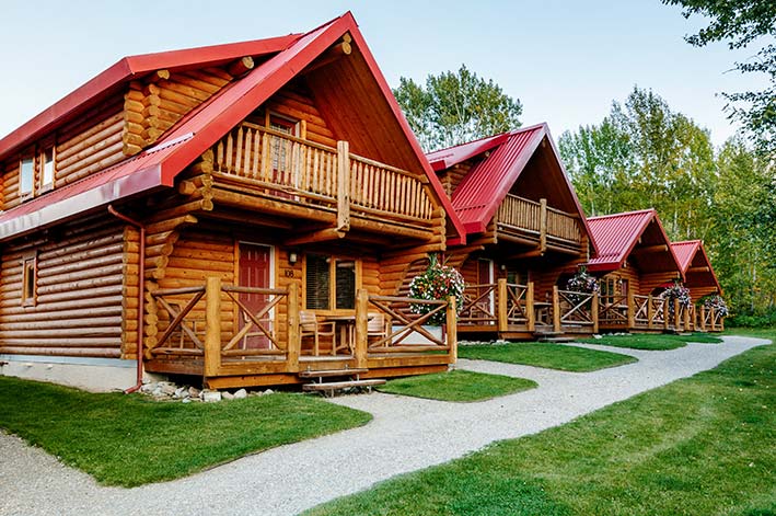 A row of wooden cabins with red roofs