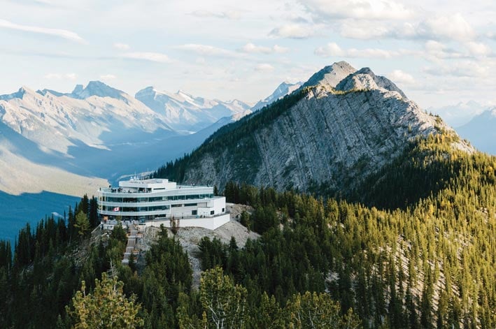 The Banff Gondola summit building atop a forested mountain ridge