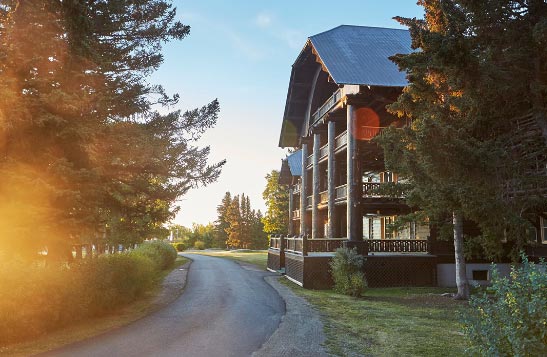 Early morning sun shines on the large wooden Glacier Park Lodge