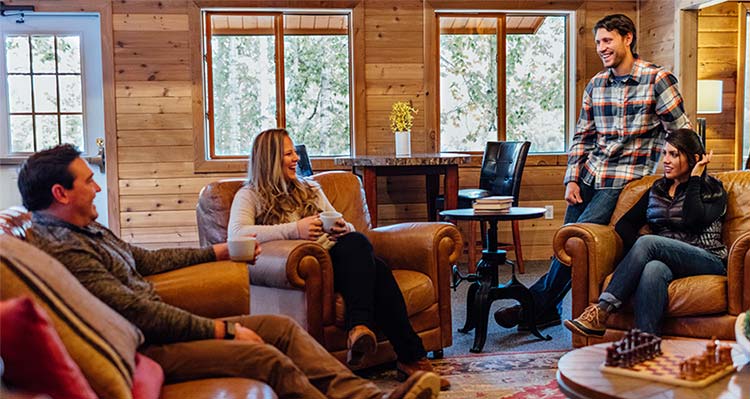Four friends relax in a lounge area at Denali Backcountry Lodge